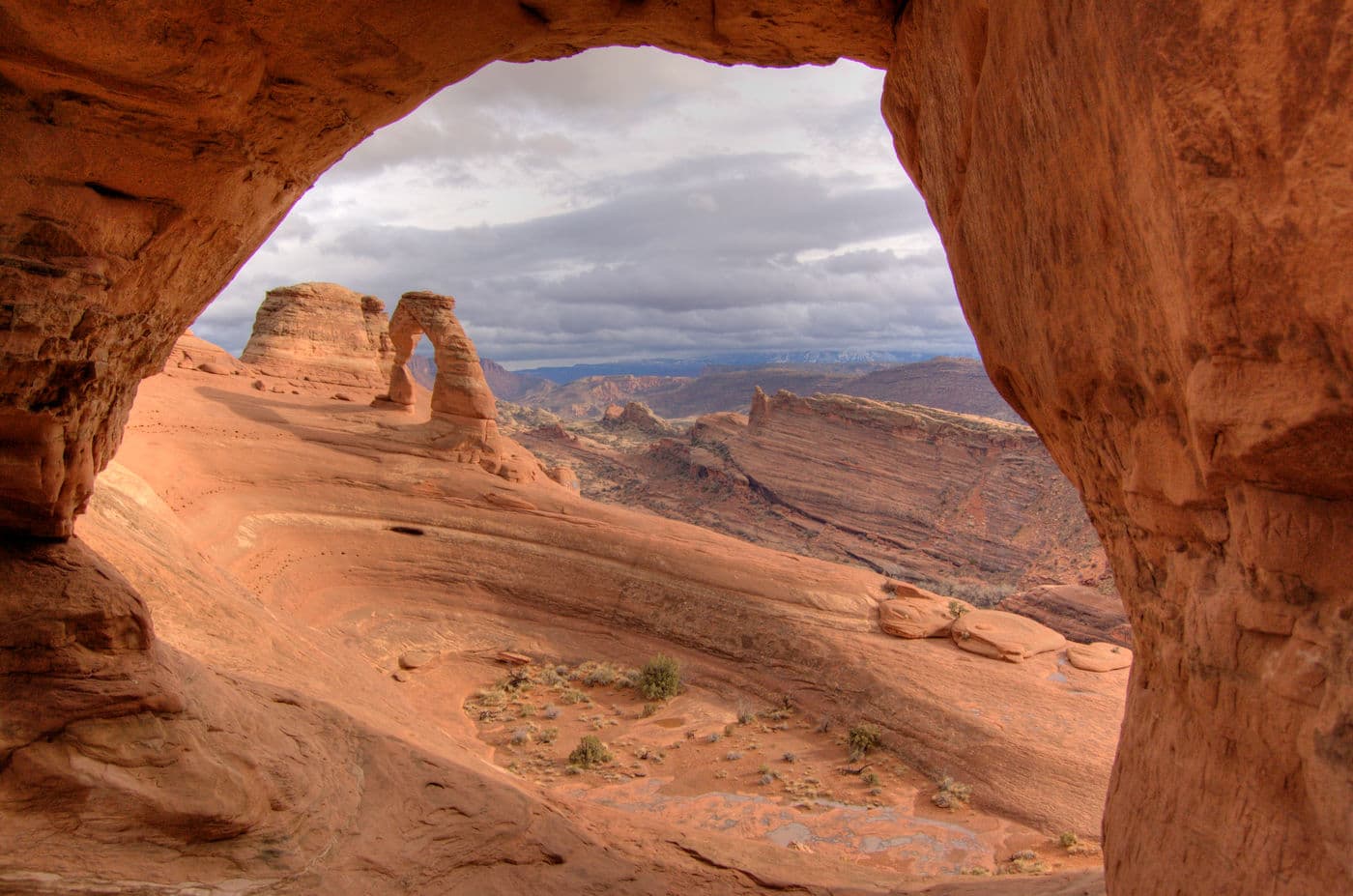 Hiking to Delicate Arch past a hole in the sandstone, I climbed up and saw Delicate Arch through the hole.